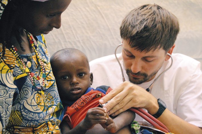 Arzt von Ärzte ohne Grenzen untersucht ein Kind